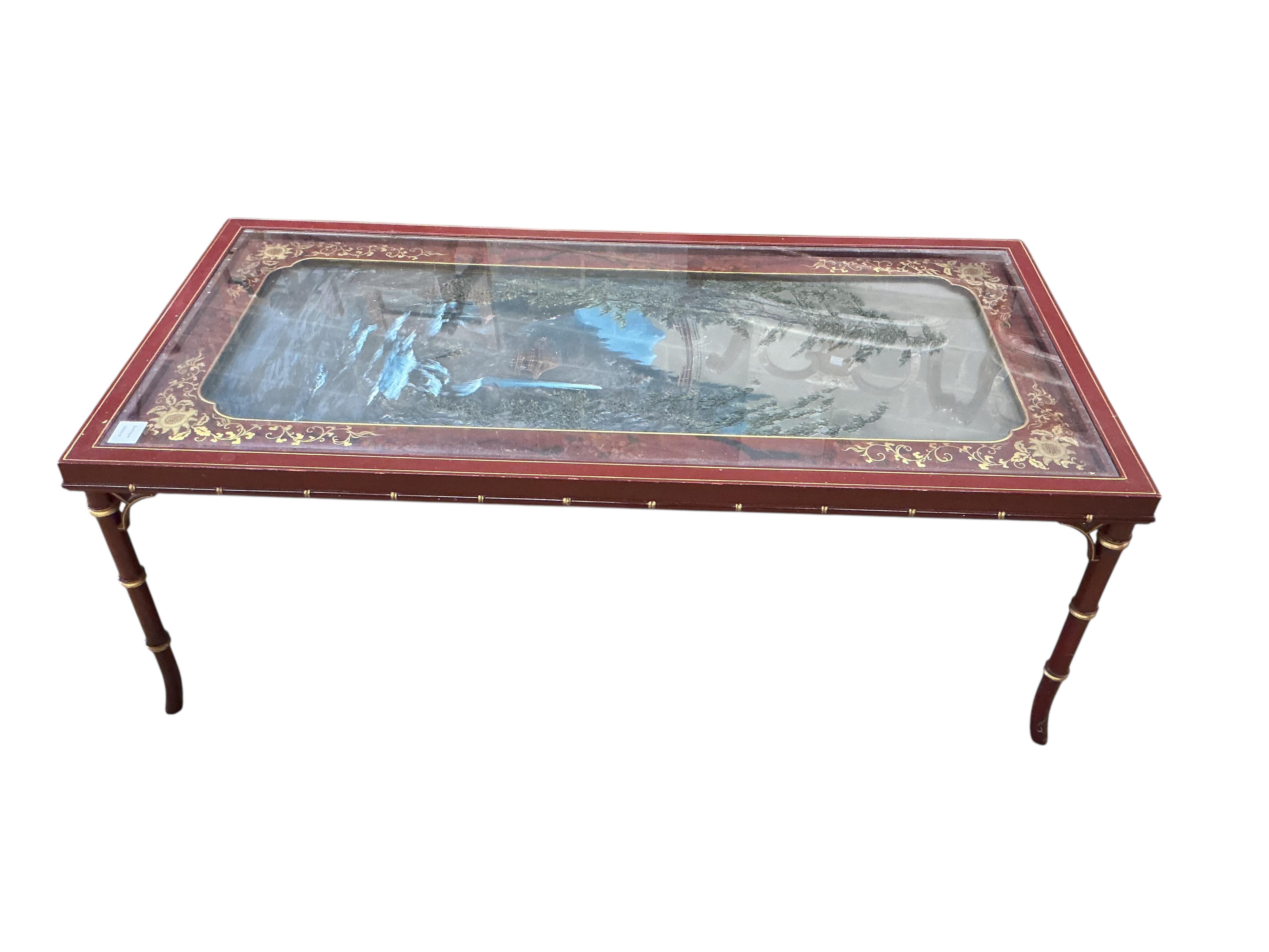 A Contemporary painted scarlet lacquer rectangular occasional table, decorated with a waterfall landscape on faux bamboo legs, width 122cm, depth 60cm, height 45cm